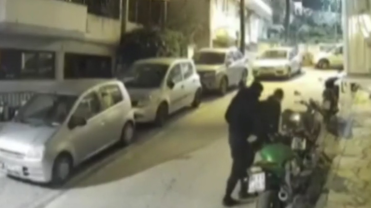 Doi bărbați în timp ce fură o motocicletă dintr-o parcare