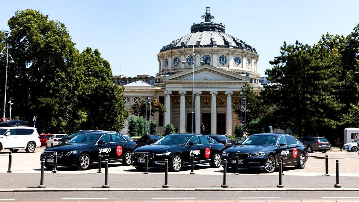 Astăzi intră în vigoare noua lege privind transportul alternativ. Șoferii Uber, Bolt, Yango sau Free Now trebuie să respecte mai multe condiții. Mașini Yango în fața Ateneului Român