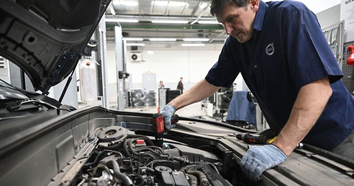 Un mecanic auto examinează motorul unei mașini, octombrie 2023