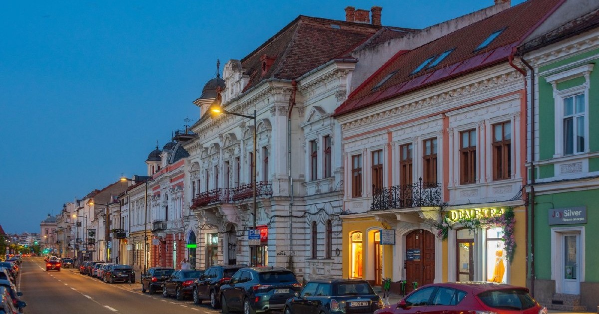 Cluj-Napoca, Romania, August 12, 2023: Apus pe Bulevardul Eroilor in Cluj-Napoca, Romania, mai multe masini sunt parcate lângă casele colorate