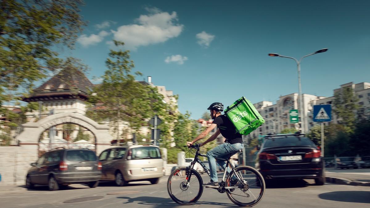 Uber Eats se lansează în București, de acum poți să comanzi mâncare de la peste 100 de restaurante din Capitală. Curier Uber Eats pe o bicicletă