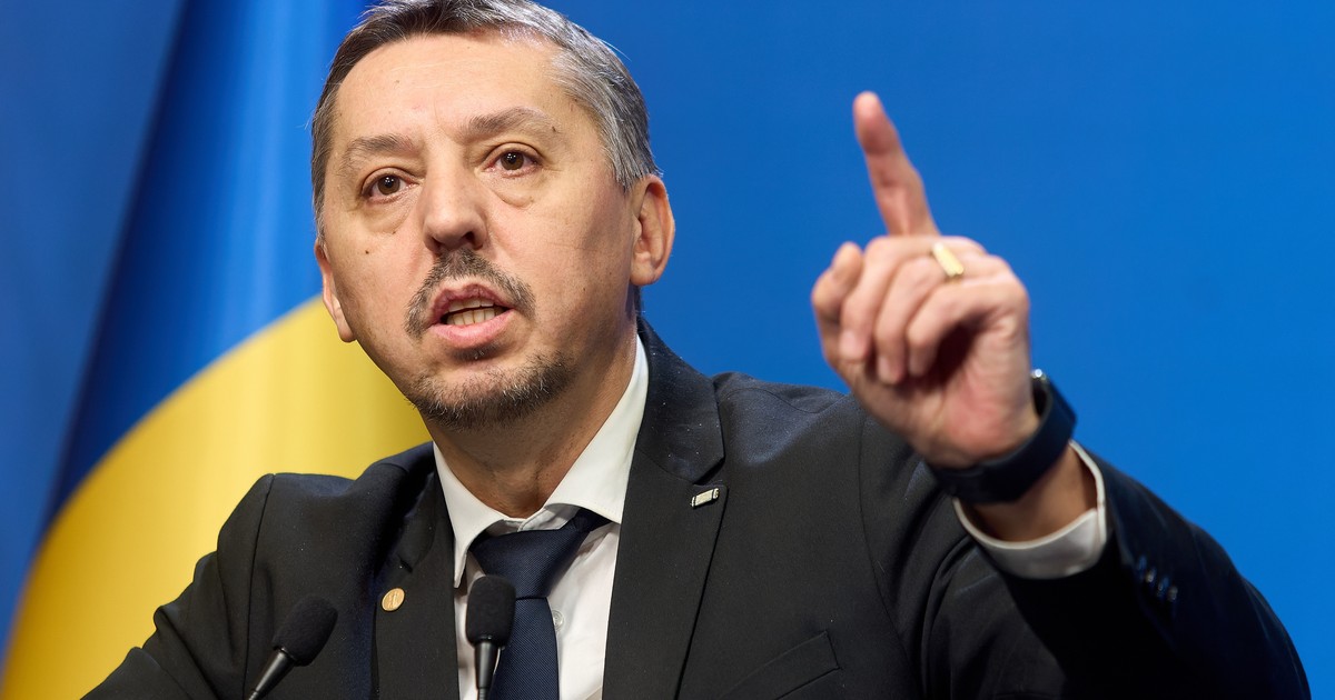 Daniel David, ministrul Educației, cu mâna ridicată vorbind în cadrul unei conferințe de presă