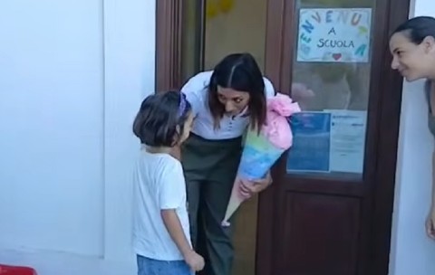 O fetiță intră în sala d eclasa, in Italia, fiind intampinata de profesoara sa