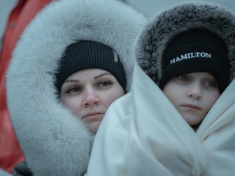 O familie pe bacul care transportă refugiați din Ucraina în România