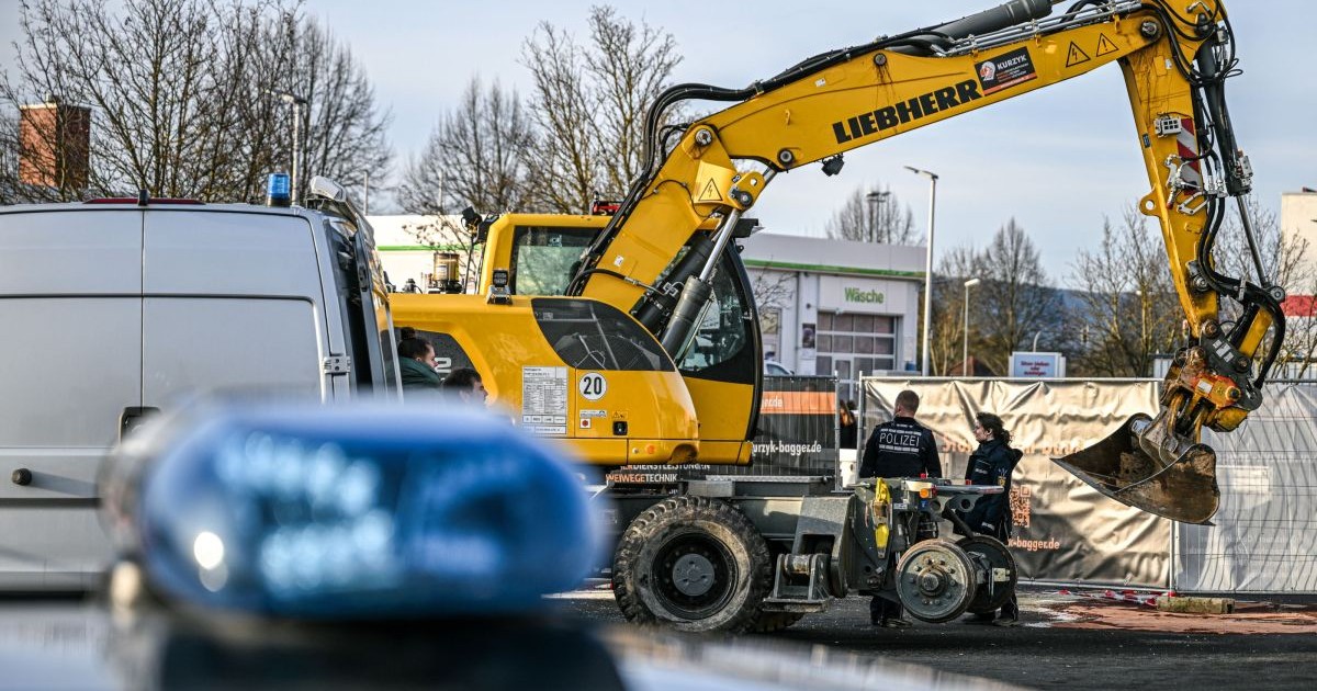 În plan apropiat se vede o sirenă de pe o mașină de poliție, în timp ce doi polițiști cercetează un excavator abandonat
