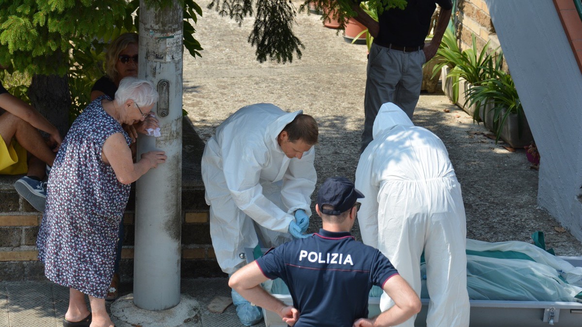 O româncă a fost găsită moartă în Italia, în locuința bătrânei pe care o îngrijea. Imagine cu criminaliștii care ridică cadavrul