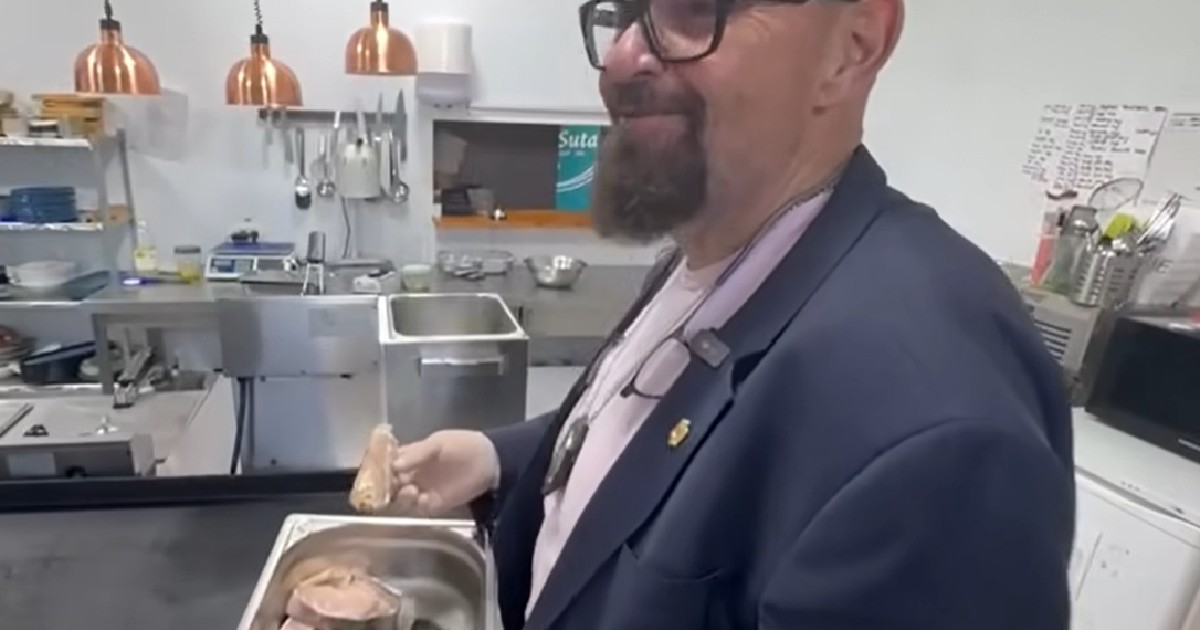 Cristian Popescu Piedone în control la un restaurant de pe litoral, ține o tavă metalică în care se află mâncare și zâmbește spre camera foto
