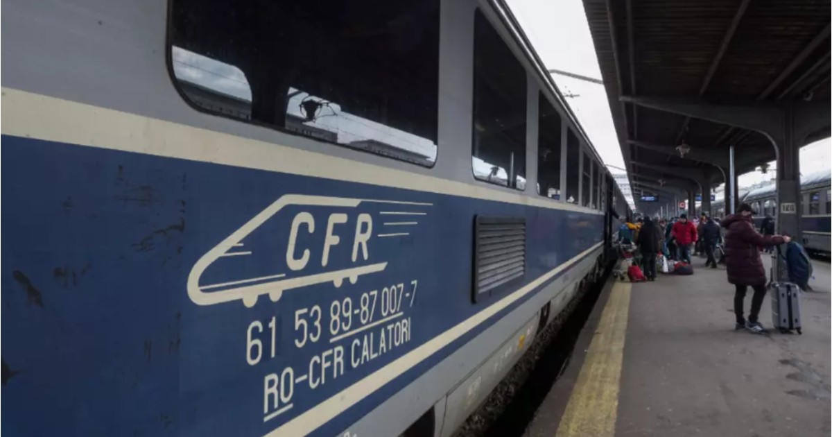 În imagine este ilustrat un tren CFR într-o gară. Pe peron se află mai mulți oameni îmbrăcați cu geci