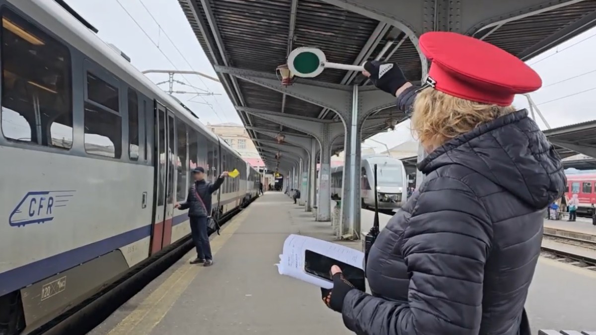 O femeie este impiegat de mișcare la un tren CFR în Gara Nord București