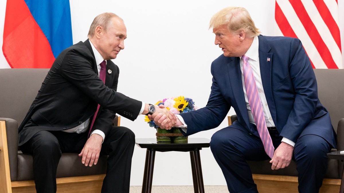 Vladimir Putin (stânga) dă mâna cu Donald Trump