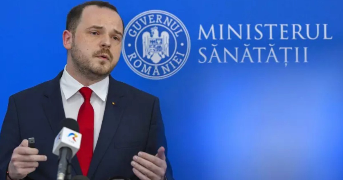 Alexandru Rogobete în timp ce face declarații. În spatele său se află un panou albastru pe care scrie Ministerul Sănătății.