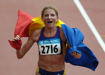 Romania's Constantina Tomescu waves as she runs to the finish line of the women's marathon at the National Stadium, also known as the "Bird's Nest" during the 2008 Beijing Olympic Games on August 17, 2008. Constantina Tomescu gave Romania their first ever women's Olympic marathon title here on Sunday as she won in a time of 2hours 26minutes 44second. AFP PHOTO / NICOLAS ASFOURI