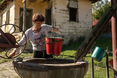 O localnică venită după apă la fântână