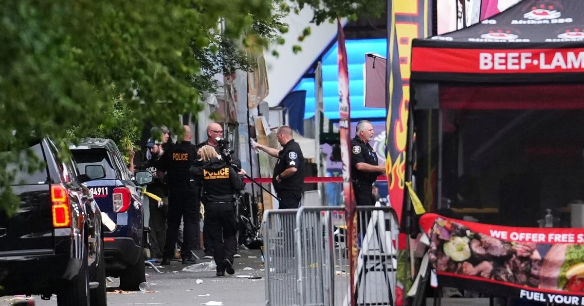 Un fotograf criminalist sosește în timp ce forțele de ordine examinează locul incidentului în urma unui schimb de focuri la Seattle Center, în timpul festivalului gastronomic „Bite of Seattle”, duminică, 26 iulie 2026.