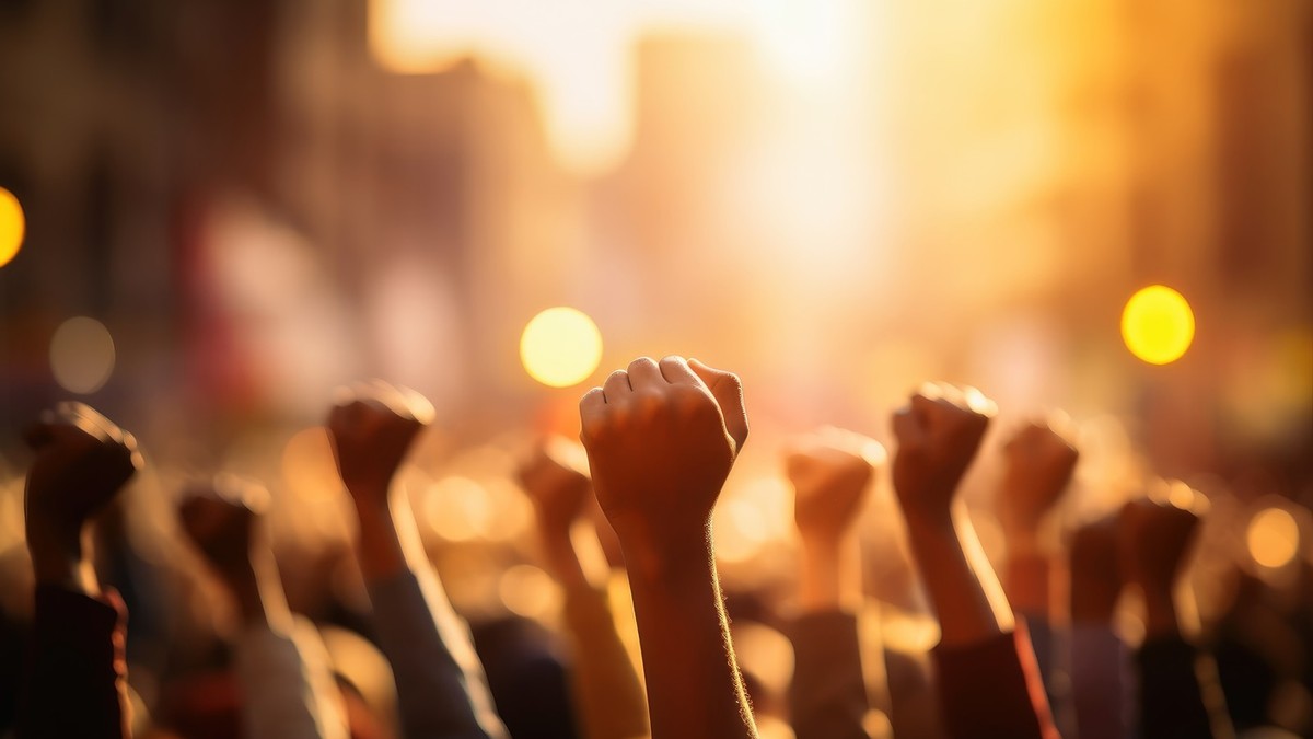 Un grup de oameni care ridică pumnul ca simbol al protestului