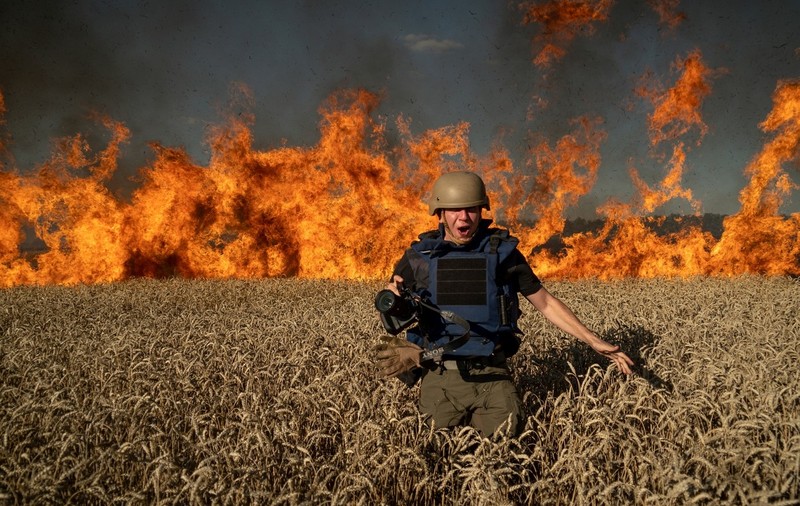 Un fotojurnalist ucrainean, surprins în timp ce fuge din calea flăcărilor care au cuprins un lan de grâu bombardat de ruși