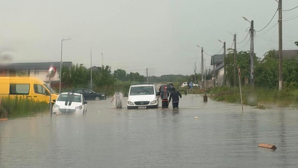 Oameni și mașini care au fost inundate în urma ploilor.