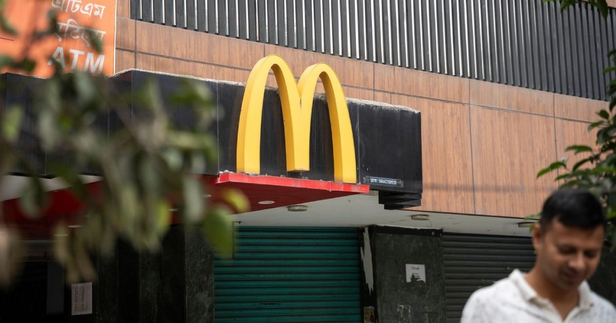 Un semn McDonalds in india se vede in fundal, in prim plan un bărbat