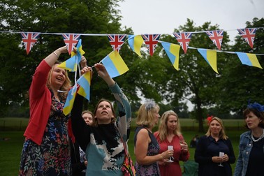 Oamenii pun steagul Ucrainei lângă cel al Marii Britanii, la picnicul „The Big Lunch” | Foto: EPA