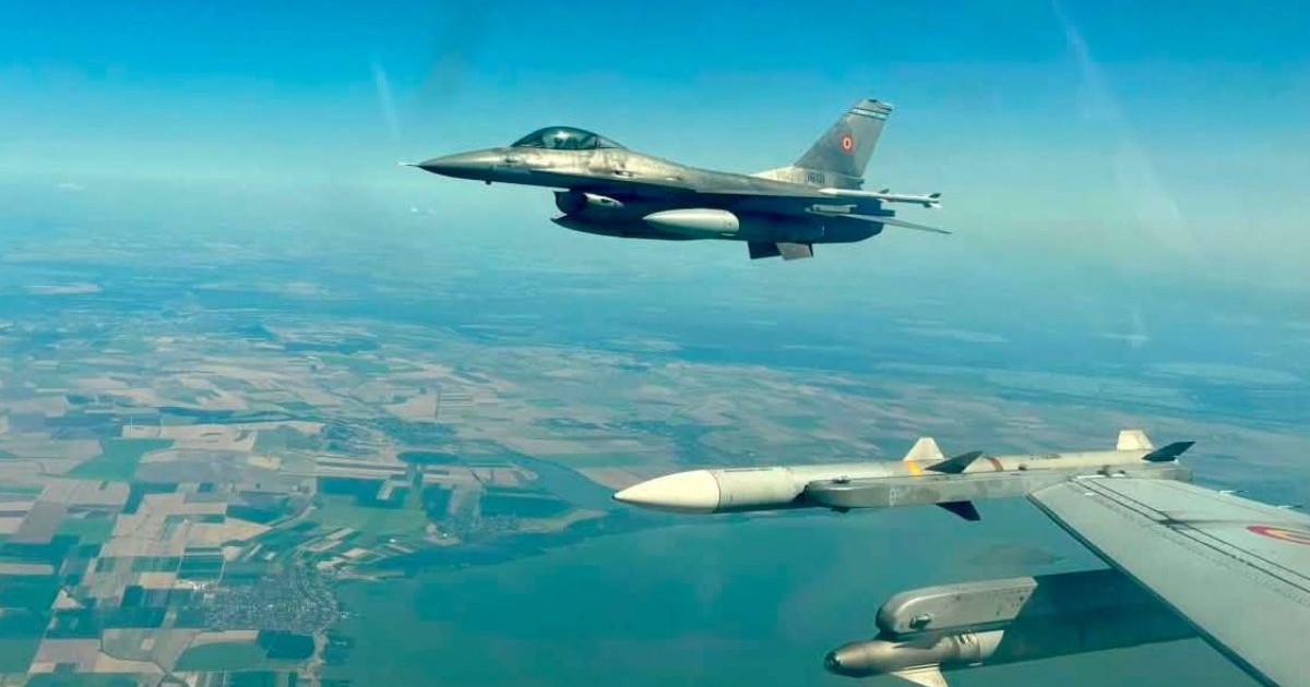 Avioane de vânătoare F-16 românești, pe cerul României, în timpul zborului, poza fiind făcută din carlinga unuia dintre ele în care se vede aripa cu rachete și al doilea avion F-16