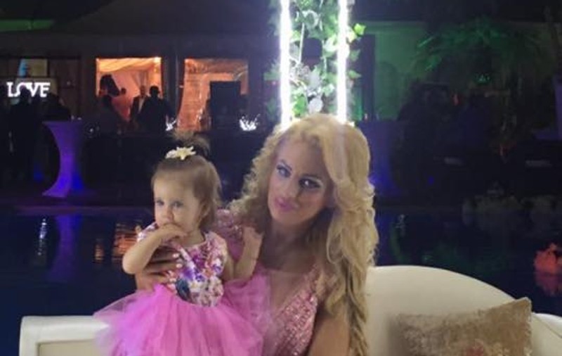 Fetița Sânzianei Buruiană bagă rufe la spălat. Mama ei a surprins momentul