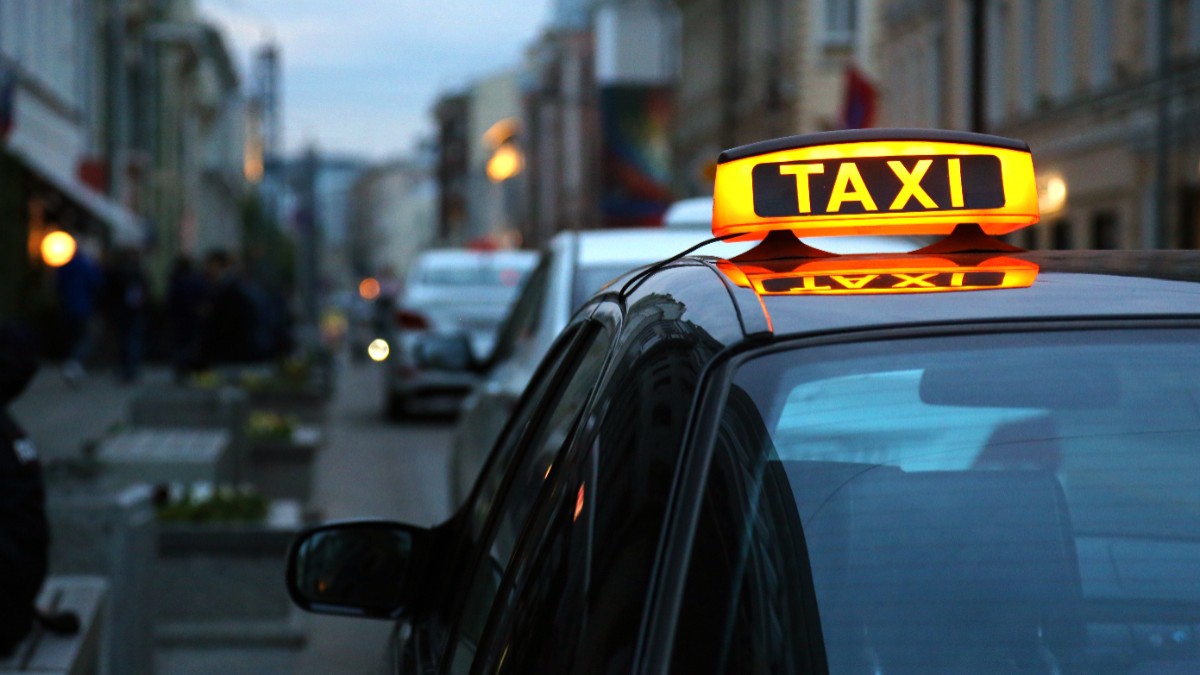 Un taxi parcat pe o stradă, noaptea.