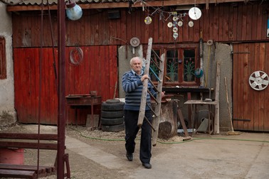 Nea Dumitru își aduce scara ca să dea jos armindenul de anul trecut Foto: Vlad Chirea