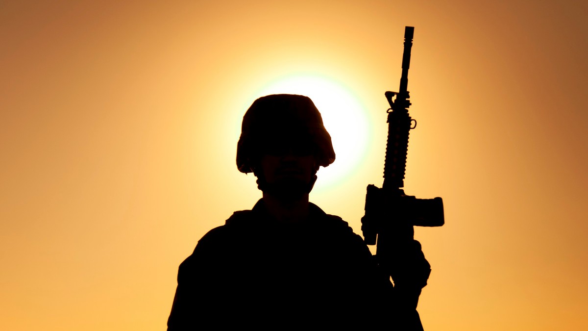 Poză cu un soldat care ține o armă în mână .