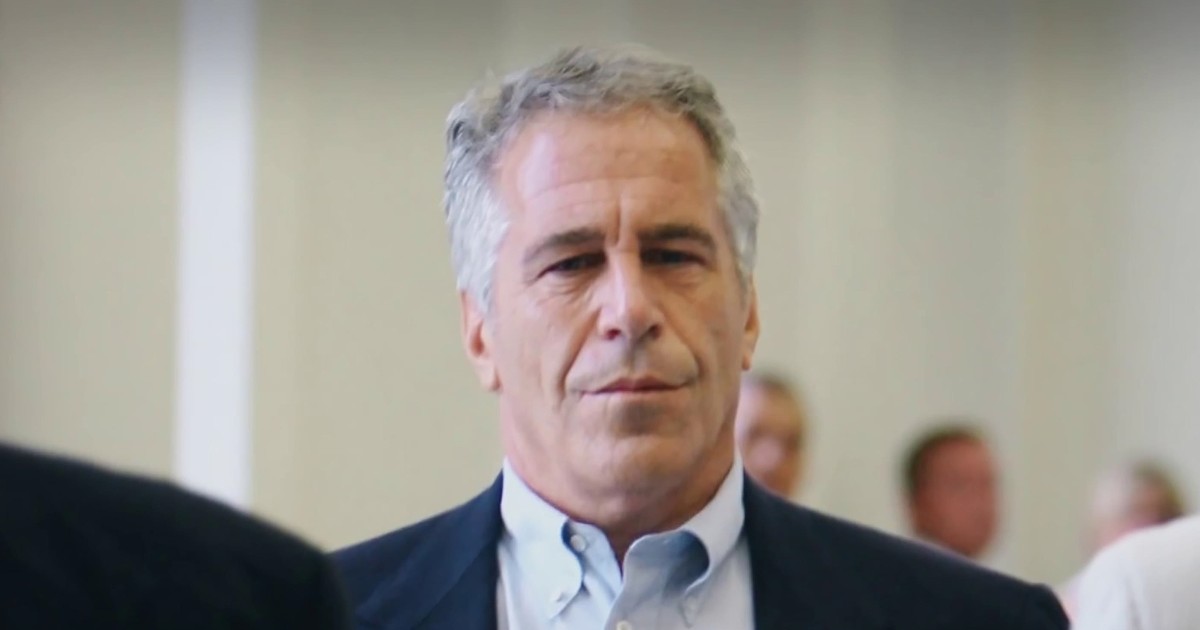 Jeffrey Epstein apare într-un cadru sobru, îmbrăcat elegant, cu o expresie serioasă, surprins într-un spațiu interior oficial. Imaginea transmite un context tensionat și grav, asociat investigațiilor și controverselor care i-au marcat numele.
