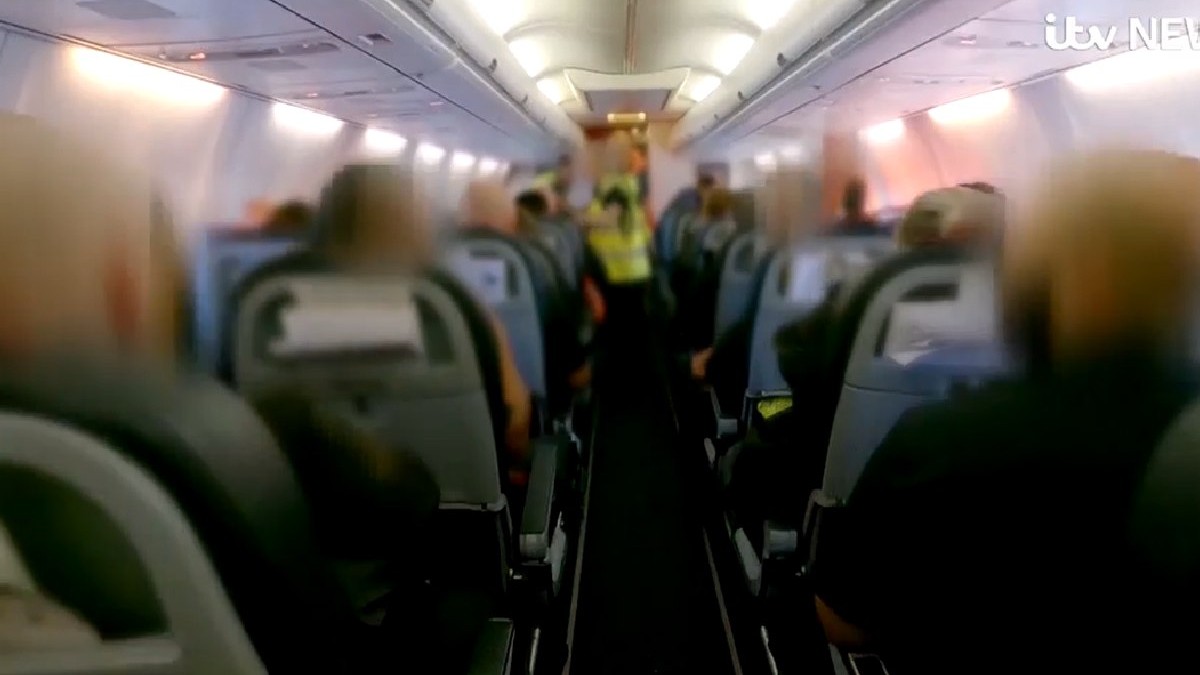 Imagini din avionul in care sunt deportati infractori români din Marea Britanie. Se văd scaunele și vestele galben fosforescent ale polițiștilor