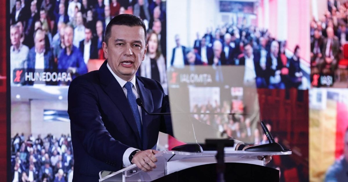 Sorin Grindeanu, îmbrăcat în costum negru, cămașă albă și cravată albastră, în timp ce susține un discurs la evenimentul Momentul Adevărului de la Palatul Parlamentului