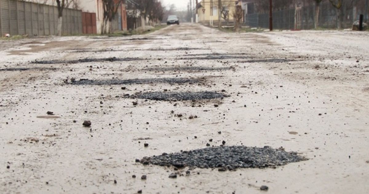 Gropi acoperite cu asfalt pe un drum de țară
