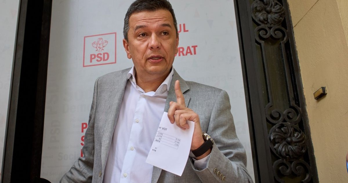 Sorin Grindeanu vorbește atenționând cu degetul arătător al mâinii drepre în care ține o fcoală de hârtie împăturită, 21 iunie 2025