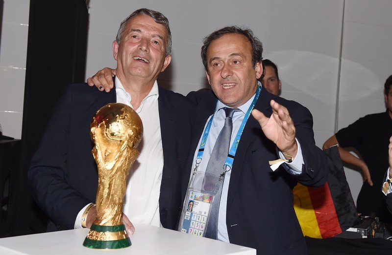 epa04315332 A handout photo released by the DFB (German Soccer Association) on 14 July 2014 shows UEFA President Michel Platini (R) congratulating DFB President Wolfgang Niersbach after Germany's victory over Argentina in the Soccer World Cup 2014 with the trophy in Rio De Janeiro, Brazil, 13 July 2014. Germany won the World Cup after defeating Argentina 1-0. EPA/MARKUS GILLIAR / DFB / HANDOUT HANDOUT EDITORIAL USE ONLY/NO SALES
