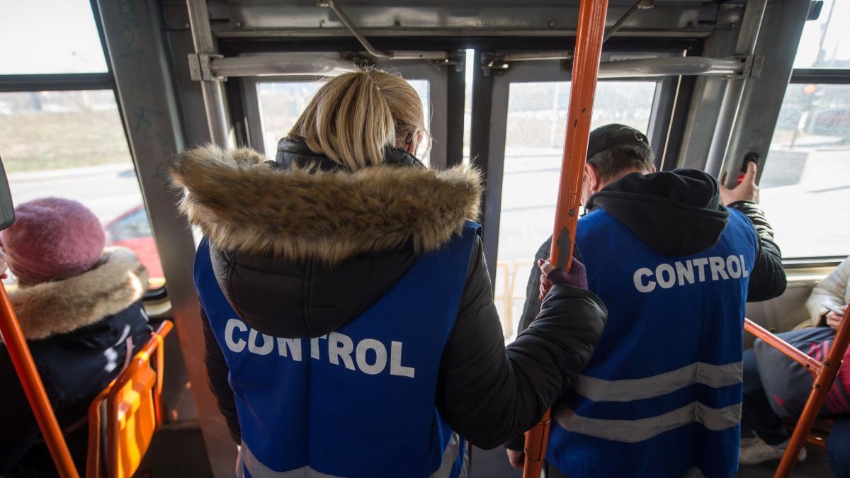 Doi angajați ai serviciului de transport coboară din tramvai după ce au verificat călătorii