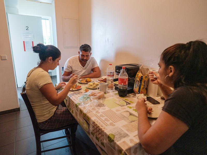 Mădălin, soția lui, Raluca, și sora lui, Adelina, iau prânzul în spațiul de cazare de la ferma Höfler Gemüse din Nürnberg. Mădălin și soția lui, Raluca, lucrează opt luni pe an în Germania, în timp ce fetița lor de patru ani crește în România cu bunica.