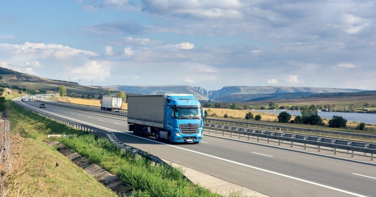 Un camion albastru care merge pe o autostrada din România, în timpul unei zile însorite