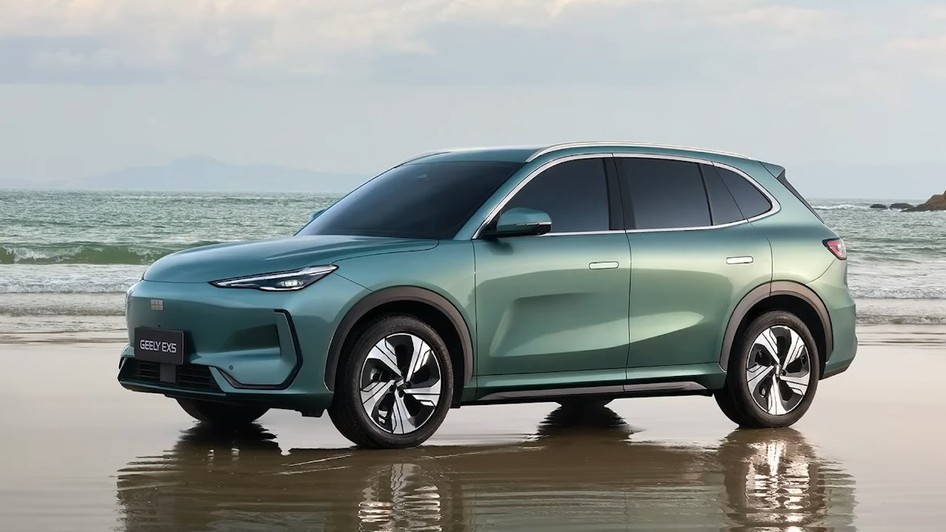 Imaginea prezintă hibridul Geely Starray EM-i  de culoare verde mentă parcat pe o plajă, pe un nisip umed care reflectă automobilul.