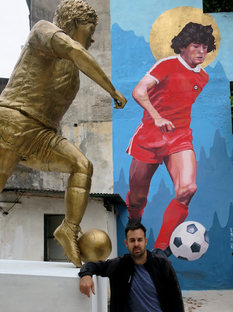 epa07132111 Cesar Perez, promoter of the tribute to Diego Armando Maradona, poses next to the statue of the Argentine icon, the day of the birthday of the Argentine player, in Buenos Aires, Argentina, 30 October 2018. An imposing mural and a large statue of Diego Armando Maradona were located a few meters from the stadium of Argentinos Juniors, in the neighborhood of La Paternal, where the world champion in Mexico 1986 debuted, who turns 58 today. EPA-EFE/SEBASTIAN MERESMAN