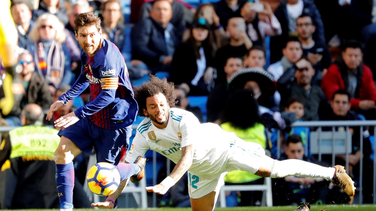 Lionel Messi (stânga), atacantul Barcelonei, trece în dribling de Marcelo, fundașul lui Real Madrid. (FOTO: EPA)