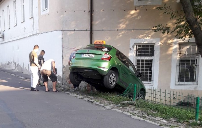 Mașină școală, implicată într-un accident bizar în Iași. A sărit peste un gard și s-a oprit în zid