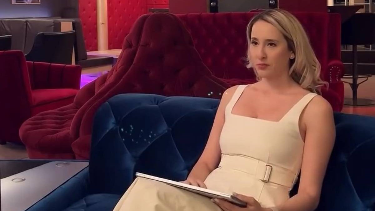 femeie blonda intr-o rochie alba care sta pe o canapea albastra
