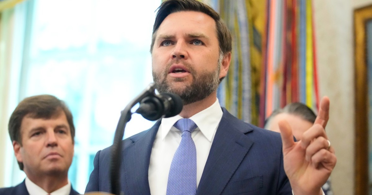 Imaginea îl surprinde pe senatorul american J.D. Vance vorbind la un microfon, la Casa Albă. Este îmbrăcat cu un costum bleumarin, o cămașă albă și o cravată albastră, iar în timpul discursului, el gesticulează cu mâna stângă. În spatele său, pe partea stângă, se observă un bărbat stând în picioare.
