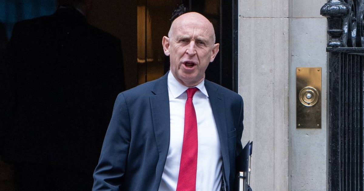 JOHN HEALEY, ministrul Apărării, in sacou gri inchis, camasa alba, cravata roșie si cu o mapă la subraț, părăsește Downing Street nr. 10 după o ședință săptămânală de cabinet.