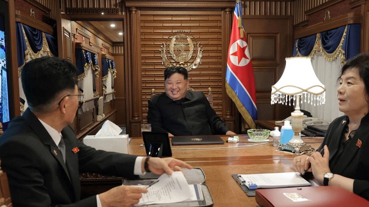 Fotografie furnizată de guvernul nord-coreean cu liderul Kim Jong Un, zambitor, asezat la birou, cu steagul pe peretele din spate, in centru, pleacă din Phenian, ,Coreea de Nord, cu trenul, luni, 1 septembrie 2025, îndreptându-se spre Beijing.