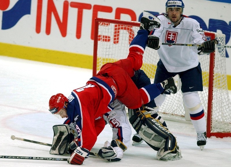 SWEDEN OUT STO06 - 20020511 - GOTHENBURG, SWEDEN : Russia's Roman Lyashenko (C) trips over Slovakia's goalie Jan Lasak (ground) while Miroslav Hlinka (R) of Slovakia looks on as Slovakia faced Russia in their final Game in the Ice Hockey World Championships in Gothenburg, Sweden, Saturday 11 May 2002. EPA PHOTO PRESSENS BILD/JAN COLLSIOO/PG/mr