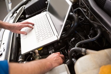 Mechanic using laptop on car at the repair garage,Image: 217788225, License: Royalty-free, Restrictions: , Model Release: no