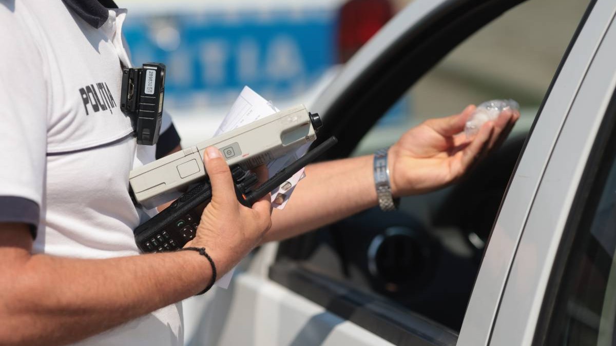 politist tine in mana o statie radio si un alcool test in timp ce a oprit un sofer in trafic