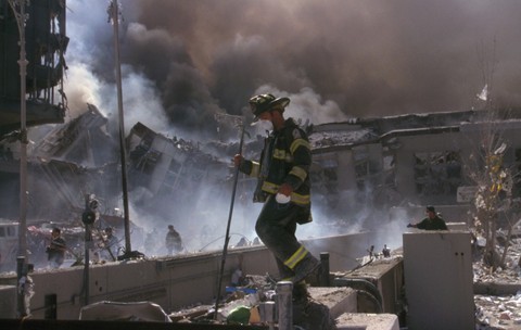 Un pompier din New York, în timp ce escaladează ruinele World Trade Center, după atacurile de la 11 Septembrie