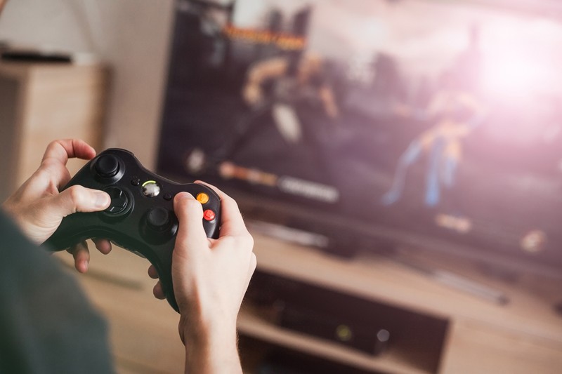 The guy is playing on the console